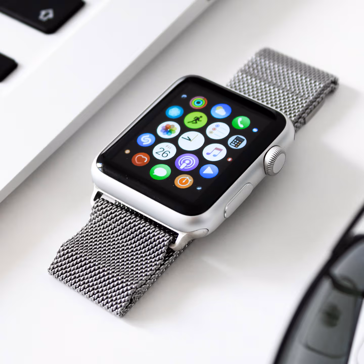 Silver Apple Watch with mesh band displaying colorful app icons
