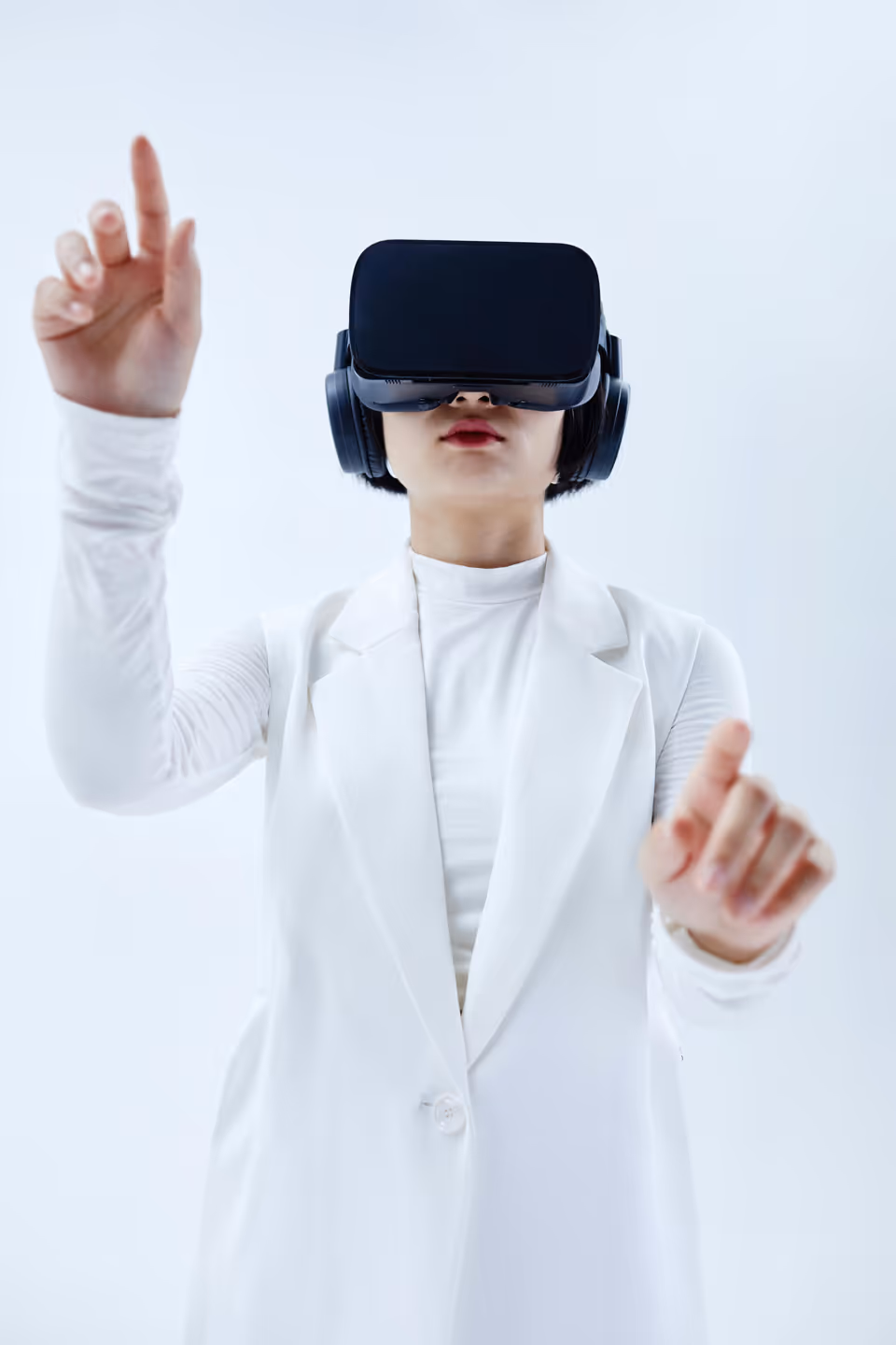 Person in white wearing VR headset gesturing with raised hands